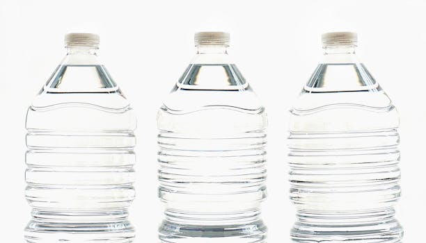 Three clear plastic bottles filled with water, standing side by side.